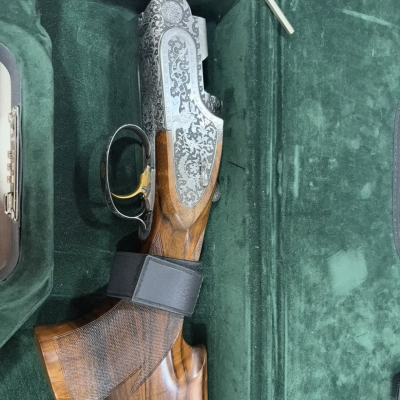 Arma de fogo com gravações e coronha em madeira num estojo verde