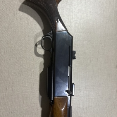 Espingarda com cabo de madeira castanha e corpo metálico preto