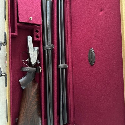 Espingarda desmontada em estojo vermelho com interior acolchoado