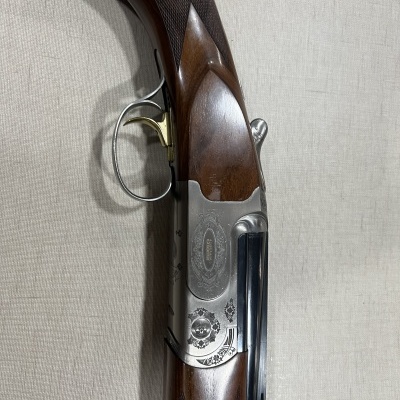 Espingarda com coronha de madeira e detalhes metálicos gravados