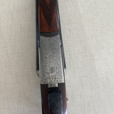 Espingarda com cabo de madeira e detalhes em metal gravado
