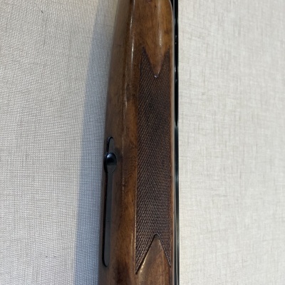 Parte de arma de fogo com coronha em madeira castanha detalhada e cano preto