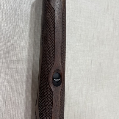 Empunhadura de arma de fogo em madeira com textura e botão preto