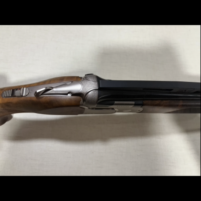 Espingarda de canos paralelos com coronha de madeira e detalhes metálicos