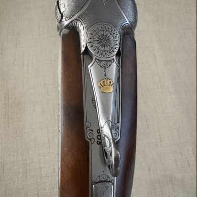 Arma de fogo antiga com cabo em madeira e detalhes metálicos gravados com coroa dourada