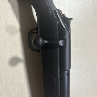 Espingarda ou rifle preto com alavanca de ação e cabo em parede bege claro