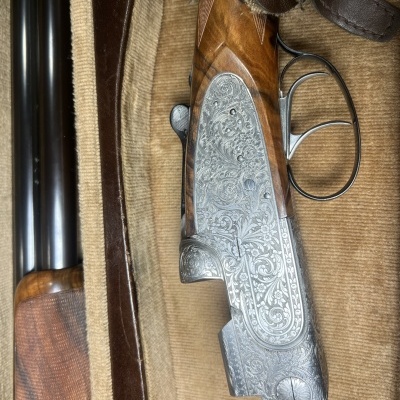 Espingarda com coronha de madeira e detalhes metálicos gravados num estojo acolchoado castanho