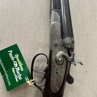 Espingarda com canos duplos e etiqueta verde da loja Sport-Nico Paulo e Mucha