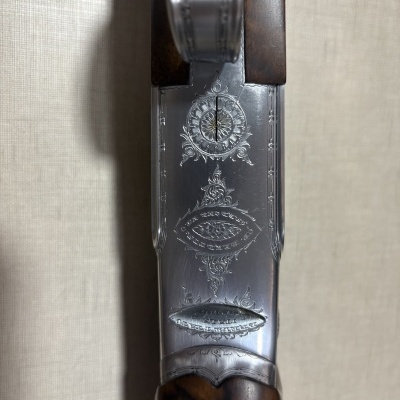 Detalhe da parte superior de uma espingarda com madeira e metal decorado