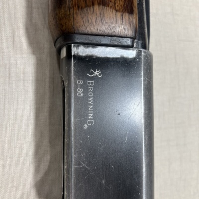 Parte metálica com inscrição BROWNING B-80 e madeira escura