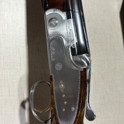 Espingarda com madeira castanha escura e metal gravado com texto D. Beretta