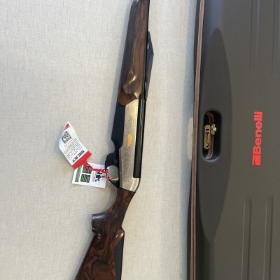 Espingarda Benelli com coronha de madeira e estojo preto ao lado