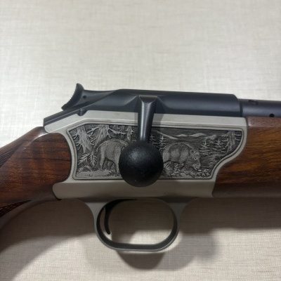 Carabina de caça com detalhe em madeira e gravação de javalis.