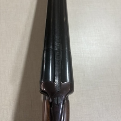 Espingarda de canos duplos paralelos com empunhadura de madeira e canos de metal negro