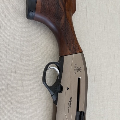 Parte traseira de espingarda BERETTA com coronha de madeira e corpo metálico cinza