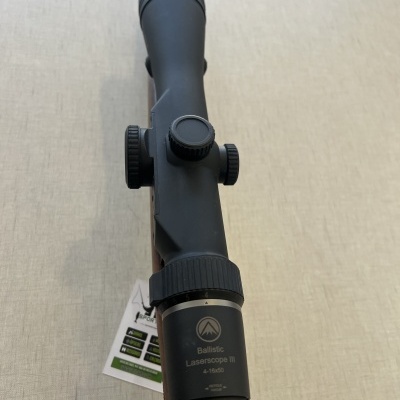 Telescópio de mira preto para arma com ajuste lateral e etiqueta pendurada