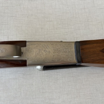 Parte de uma arma de fogo com gravações e madeira castanha