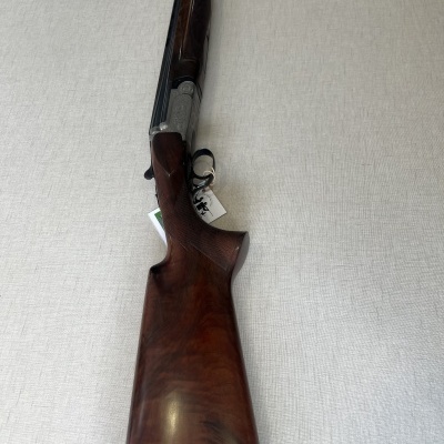 Espingarda de cano duplo com madeira castanha e detalhes metálicos escuros