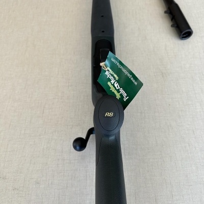 Rifle de caça preto com etiqueta verde e inscrição R8