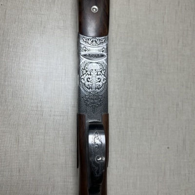 Espingarda com detalhes metálicos ornamentais e madeira castanha escura