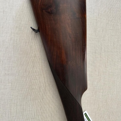 Coronha de espingarda em madeira escura com punho texturizado e proteção de borracha preta