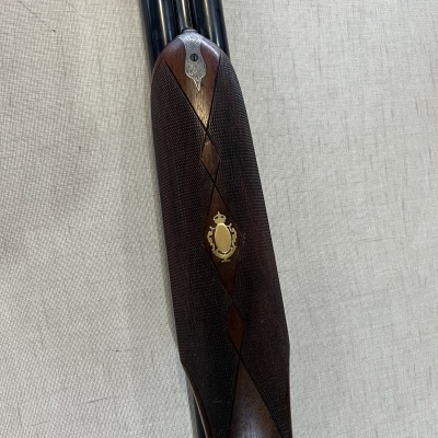 Espingarda de canos duplos com cabo em madeira escura texturada