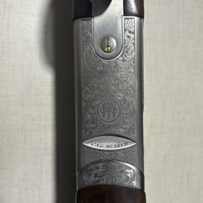 Parte central metálica gravada de espingarda com alça de madeira escura