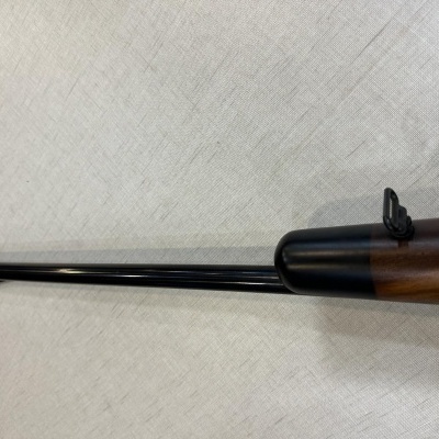 Arma de fogo com cano longo preto e cabedal em madeira castanha