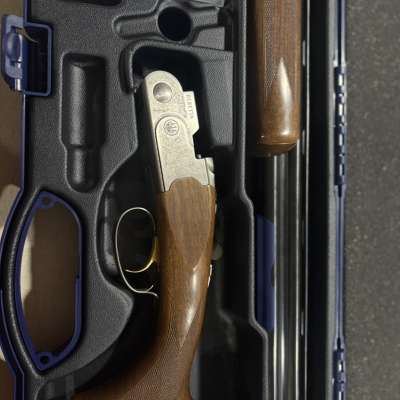 Espingarda Beretta com cabo de madeira em estojo de transporte.