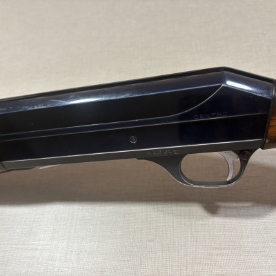 Caixa e gatilho de arma de fogo com punho em madeira castanha e metal preto com inscrição CENTRO