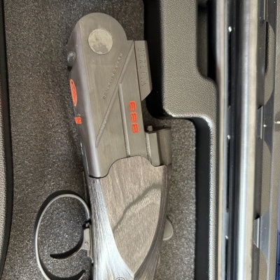 Espingarda Beretta 688 com detalhes em laranja num estojo acolchoado preto
