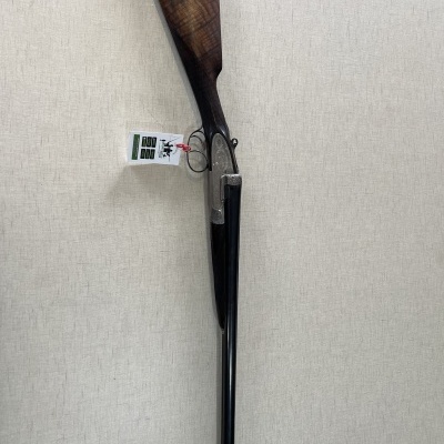 Espingarda de cano duplo com coronha em madeira castanha e etiqueta pendurada