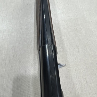 Arma de cano duplo preta sobre superfície clara