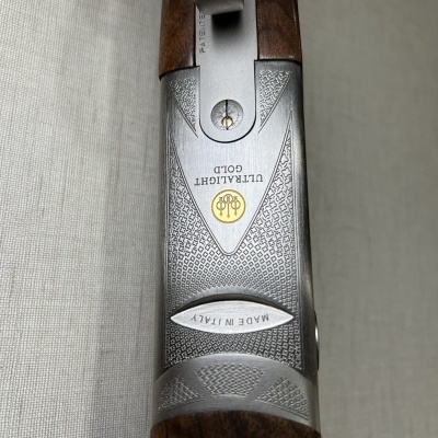 Parte superior metálica da espingarda com madeira e gravações