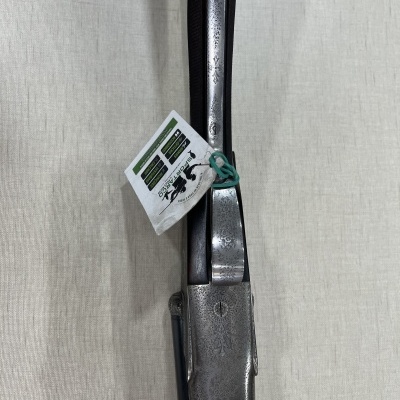 Espingarda de caça com detalhes metálicos gravados pendurada com cartão branco