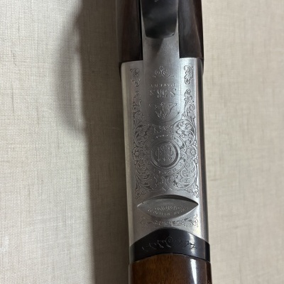 Espingarda com acabamento em metal gravado e coronha em madeira castanha