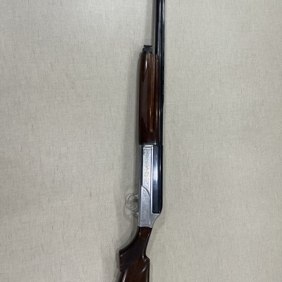 Espingarda de cano duplo com coronha em madeira e detalhes em metal gravado