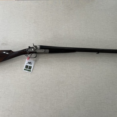 Espingarda dupla com coronha de madeira e canos longos em metal negro