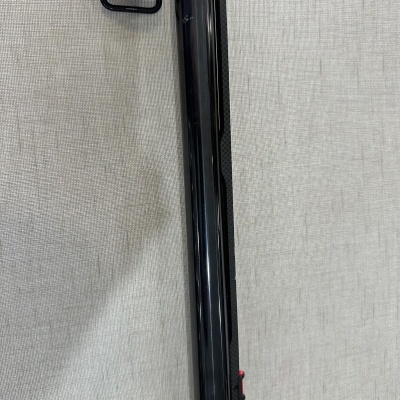 Cano de arma de fogo preto brilhante sobre fundo bege texturizado