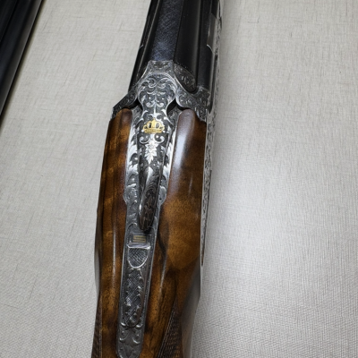 Espingarda de canos duplos com coronha de madeira e detalhes metálicos gravados