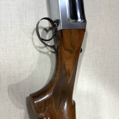 Espingarda com cabo de madeira castanha e detalhes metálicos