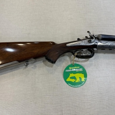 Espingarda de cano duplo com madeira polida e etiqueta verde pendurada