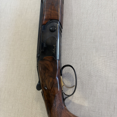 Espingarda em madeira castanha escura e metal preto com gravação P. Beretta