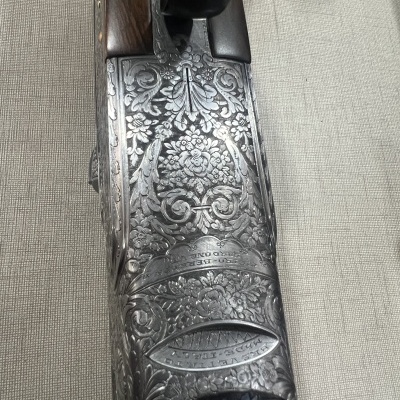 Parte de espingarda com gravações florais em metal e madeira escura