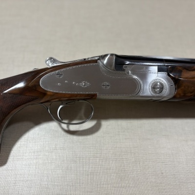 Espingarda de canos duplos em madeira escura e metal prateado gravado