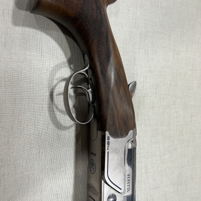 Arma de caça de madeira escura e metal prateado com texto BERETTA TSS