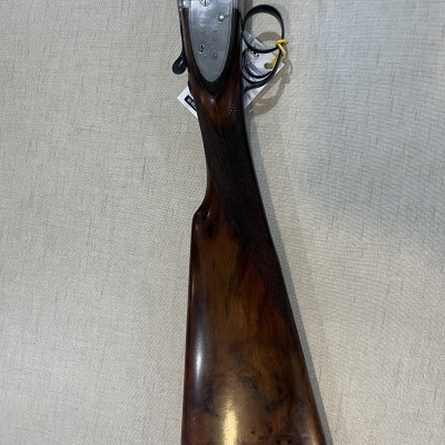 Espingarda com canos duplos, coronha de madeira castanha polida e metal prateado