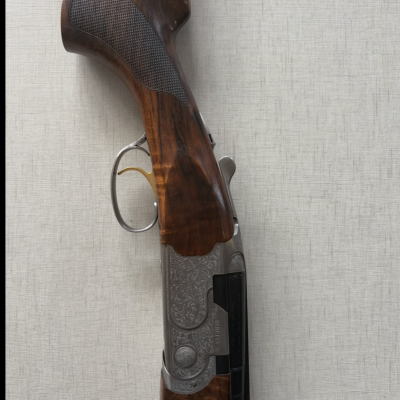 Parte de espingarda com punho em madeira castanha e detalhes em metal prateado