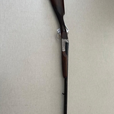 Espingarda de cano duplo com coronha em madeira castanha escura e cano metálico preto