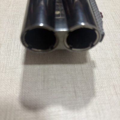 Canos duplos metálicos pretos brilhantes em superfície bege clara texturada